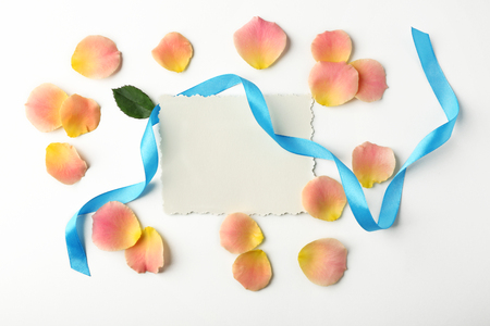 Rose petals, ribbon and card on white backgroundの写真素材