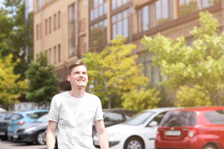 Handsome man listening music on streetの写真素材