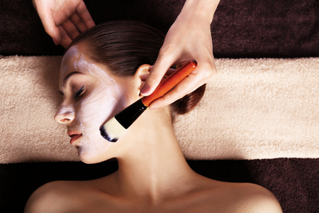 Young woman in beauty salon having face maskの写真素材