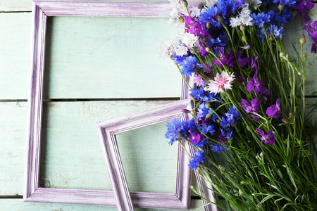 Retro frames with wild flowers on wooden background, top viewの写真素材