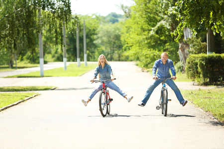 Happy couple riding bicycles in the parkの写真素材