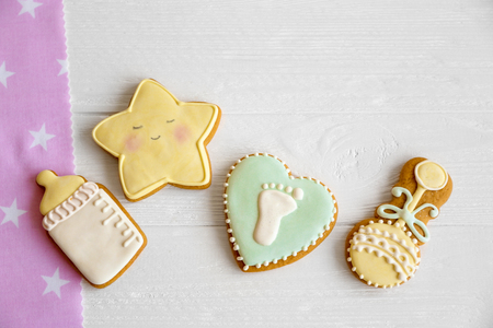 Baby cookies decorated with glaze on light wooden backgroundの写真素材