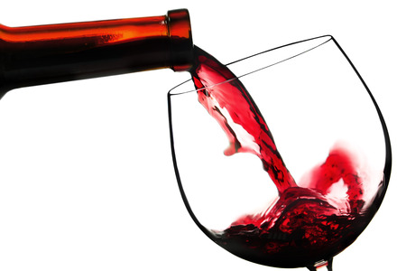 Red wine pouring in glass, isolated on whiteの写真素材