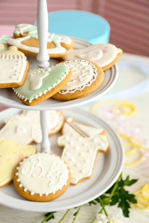 Baby glazed cookies in stand on decorated tableの写真素材