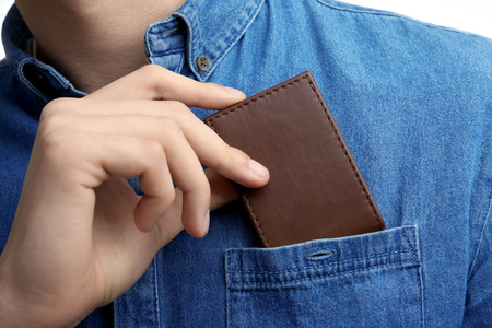 Man putting wallet in shirt pocket, closeupの写真素材