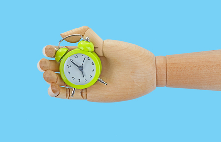 Wooden hand holding alarm clock on white backgroundの写真素材