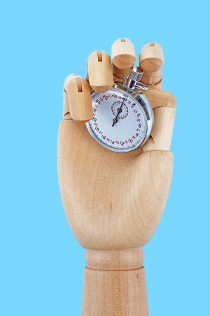 Wooden hand holding stopwatch on white background
