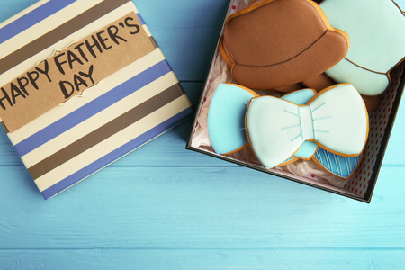 Happy Father's Day concept. Tasty cookies and gift box on blue wooden backgroundの写真素材