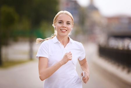 Beautiful girl running in spring parkの写真素材