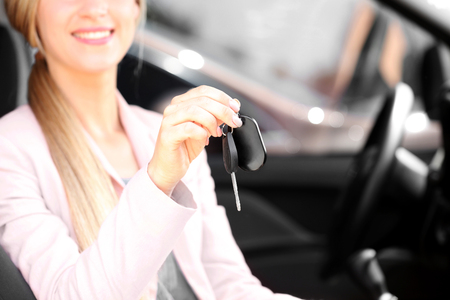 Woman holding key inside carの写真素材