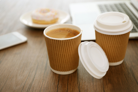 Paper cups of coffee on wooden table closeupの写真素材