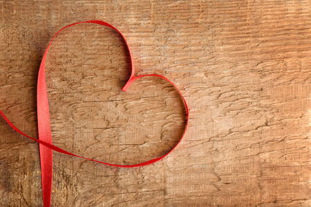 Heart shaped ribbon on wooden backgroundの写真素材
