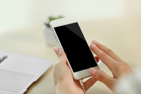 Female hand holding smartphone, closeupの写真素材