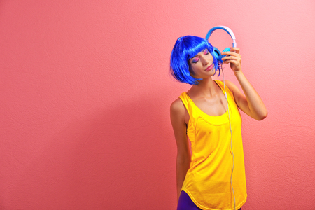 Glamour young woman with headphones on pink backgroundの写真素材