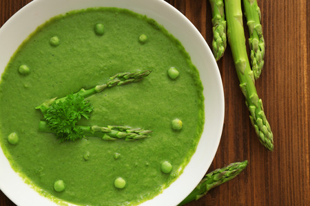 Tasty asparagus soup on tableの写真素材