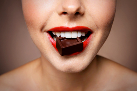 Girl eating chocolate, closeupの写真素材