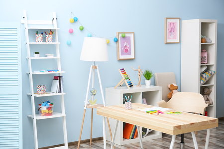 Wooden table in blue children room interiorの写真素材