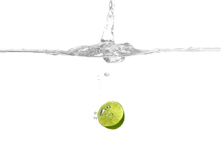 Lime falling into water on white backgroundの写真素材