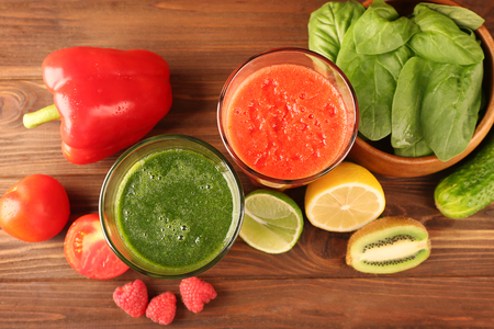 Tasty smoothie drinks with vegetables and fruits on tableの写真素材