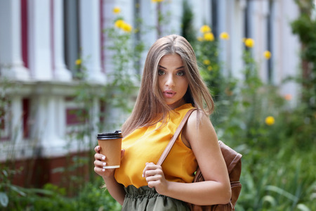 Beautiful woman  with cup of coffee on the streetの写真素材