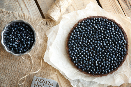 Delicious chocolate tart with berries on wooden backgroundの写真素材