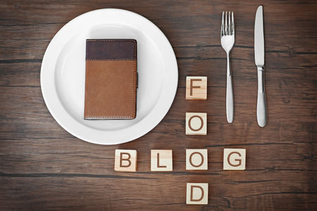 Wooden cubes with words FOOD BLOG and notebook on plateの写真素材