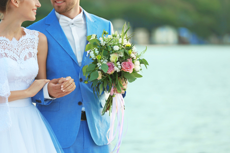 Happy wedding couple on river backgroundの写真素材