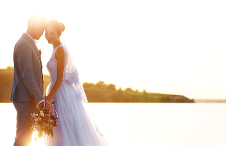 Groom and bride on sunset backgroundの写真素材