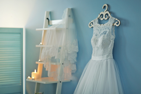 Beautiful wedding dress on hanger in roomの写真素材