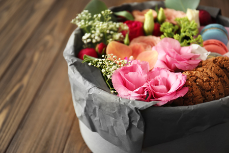 Gift box with flowers and cookies on wooden table closeupの写真素材