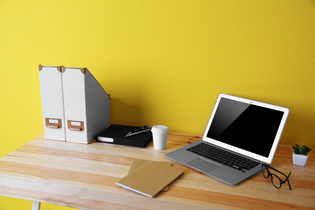 Working place on yellow wall backgroundの写真素材