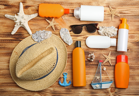 Sun protection accessories on wooden background
