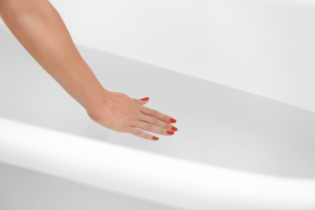Female hand in water in bathroomの写真素材