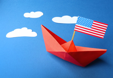 Paper boat with American flag on blue background. Happy Columbus day conceptの写真素材