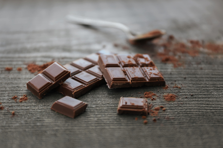 Pile of milk chocolate bars on old wooden background