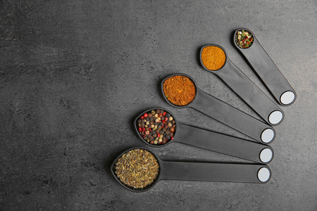 Different spices in spoons on tableの写真素材