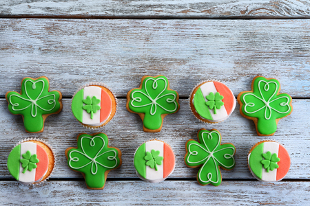 Decorative cookies and cupcakes on wooden background. Saint Patrics Day conceptの写真素材