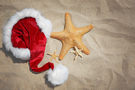 Santa hat with sea stars on beachの写真素材