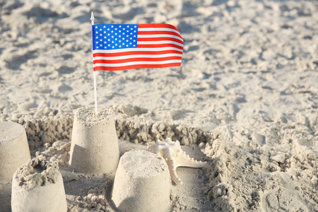 Sand castle with American flag on beach