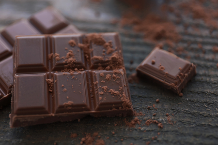 Pile of milk chocolate bars on old wooden background