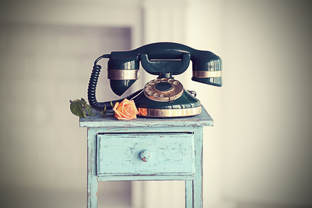 Vintage telephone on rustic blue nightstandの写真素材