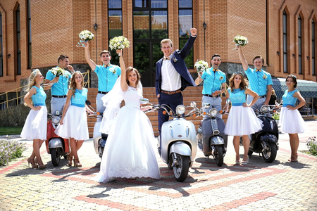 Newlyweds, bridesmaids and best men with scootersの写真素材