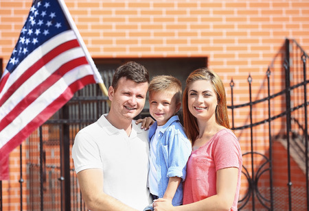 Happy family with American flag in the yardの写真素材