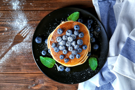 Tasty pancakes with blueberries and mint on tableの写真素材
