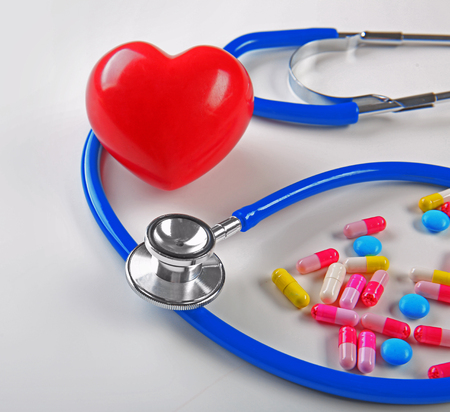 Stethoscope, pills and heart on white background, closeupの写真素材
