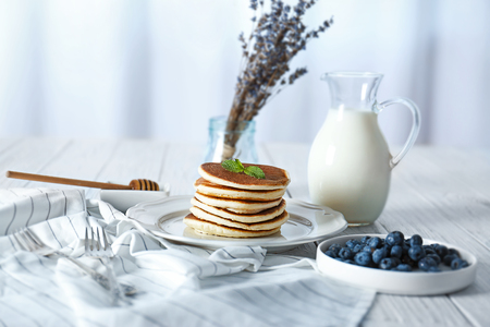 Tasty pancakes with blueberries and mint on tableの写真素材