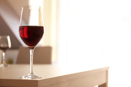 Glass of red wine on table in restaurantの写真素材