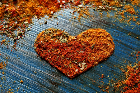 Different spices in heart shape on wooden backgroundの写真素材