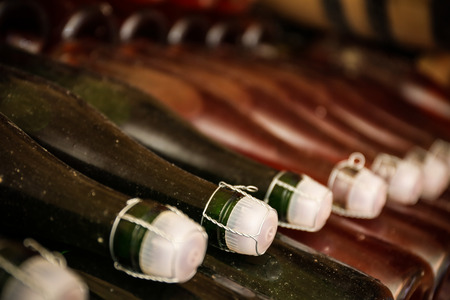 Bottles with wine in cellar, closeup