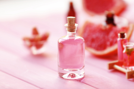 Bottle with essential oil on pink wooden tableの写真素材